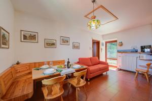 - un salon avec une table et un canapé rouge dans l'établissement Charming Magognino Stresa Hills Lake View - Happy Rentals, à Stresa