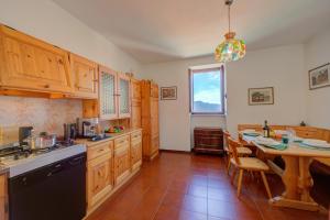 - une cuisine avec des placards en bois et une table dans l'établissement Charming Magognino Stresa Hills Lake View - Happy Rentals, à Stresa