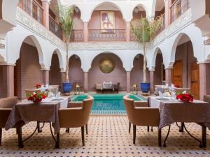 a restaurant with tables and chairs and a pool at Riad Magda & Spa in Marrakech