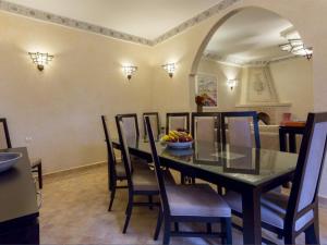 - une salle à manger avec une table, des chaises et une corbeille de fruits dans l'établissement Riad Magda & Spa, à Marrakech