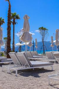 a group of lounge chairs and umbrellas on a beach at Belvedere Hotel in Vlorë