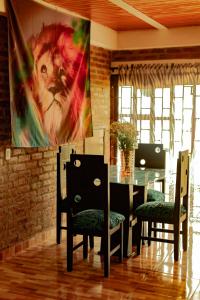 un comedor con mesa, sillas y una pintura en Casa Africa, en Calima