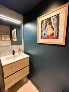 La salle de bains est pourvue d'un lavabo et d'une peinture murale. dans l'établissement Centre ville AIX - Terrasse / Ascenseur - Rénové, à Aix-en-Provence