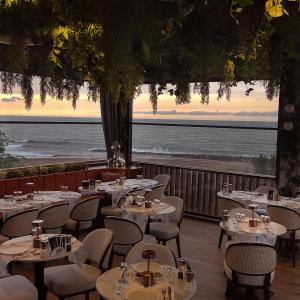 un restaurante con mesas y sillas con vistas al océano en Pikola Otel, en Ordu