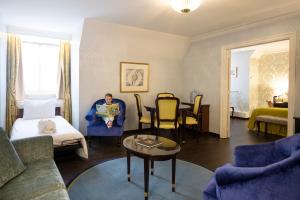 a man sitting in a blue chair in a living room at Stanhope Hotel by Thon Hotels in Brussels