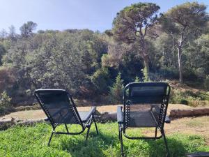 two chairs sitting in the grass in a field at Loft Vallromanes in Vallromanes