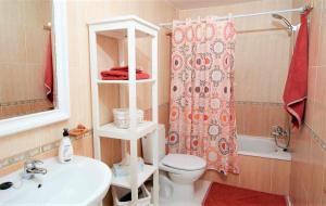 a bathroom with a toilet and a sink and a shower at Bonita vivienda con vistas al mar playaWIFI in Radazul