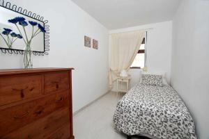 ein Schlafzimmer mit einem Bett, einer Kommode und einem Fenster in der Unterkunft Bonita vivienda con vistas al mar playaWIFI in Radazul