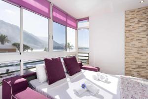 Schlafzimmer mit einem Bett mit lila Stühlen und Fenstern in der Unterkunft Estudio Océano Indico con piscina y mar y vistas in Santa Cruz de Tenerife