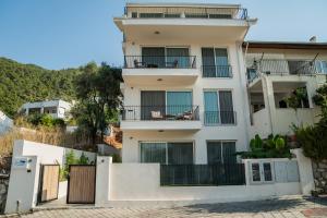een wit appartementencomplex met een balkon bij Gizz Suites City in Fethiye