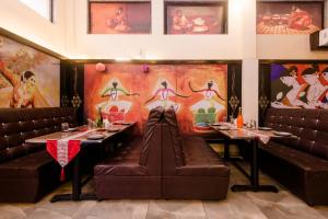a dining room with two tables and leather seats at Hotel Phoenix in Mumbai