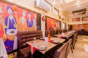 une salle à manger avec de longues tables et des fauteuils en cuir dans l'établissement Hotel Phoenix, à Mumbai