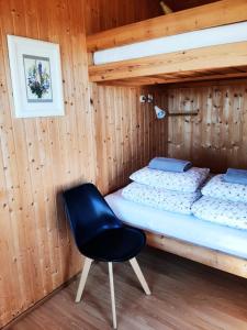 a bedroom with a bed and a chair in it at Lambhus Glacier View Cabins in Höfn