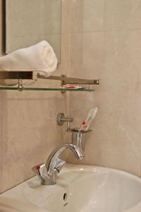 a bathroom sink with a faucet and a mirror at Hotel Airport Gurkha in Kathmandu