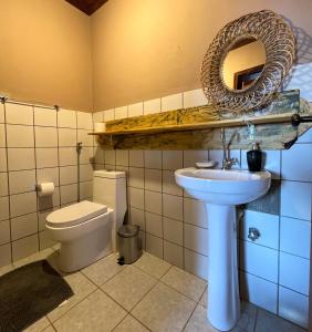 a bathroom with a sink and a toilet and a mirror at Pousada Mundo Dha Lua in Sao Jorge