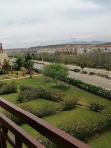 a view of a park with a fence and a street at Appartement Saidia avec piscine in Saïdia