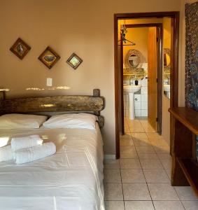 a bedroom with a white bed and a bathroom at Pousada Mundo Dha Lua in Sao Jorge