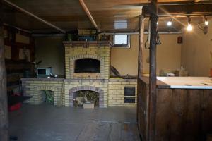 a kitchen with a brick fireplace in a room at Argo Guest House in Karakol