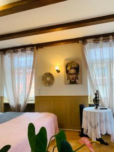 Schlafzimmer mit einem Bett, einem Tisch und Vorhängen in der Unterkunft Hotel Restaurant Syrtaki in Gernsbach