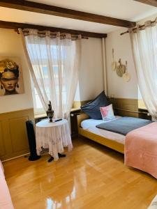 1 Schlafzimmer mit 2 Betten und einem Tisch in der Unterkunft Hotel Restaurant Syrtaki in Gernsbach