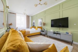 a living room with a couch and a tv at Starowiślna Elegant Apartment with Air Conditioning Kazimierz Cracow by Renters Prestige in Krakow