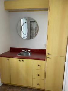a bathroom with a sink and a mirror at Chalets Plage St-Jean 2 in Saint-Jean