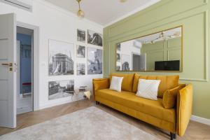 a living room with a yellow couch and a mirror at Starowiślna Elegant Apartment with Air Conditioning Kazimierz Cracow by Renters Prestige in Krakow