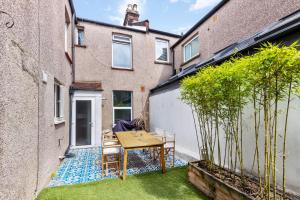 a small courtyard with a table and chairs on a patio at Lovely 2 bed Streatham apt with outside dining in London