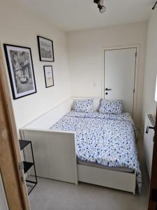 Dormitorio blanco con cama con almohadas azules en Phoenix, en Gante