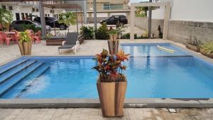 a pool in a building with flowers on the side at Pousada Sophia Beach in Salinópolis