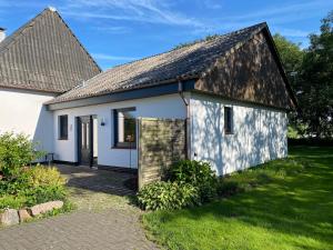 a small white house with a gambrel roof at Ferienwohnung Lüttje Glück in Böxlund