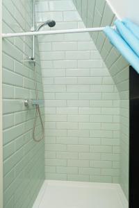 een badkamer met een douche met witte tegels bij Modern Apartment in South West London in Londen