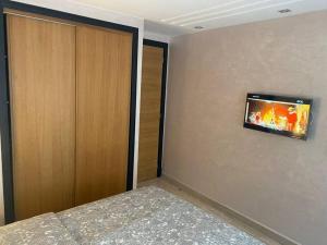 a bedroom with a wall with a tv on the wall at Appart de standing au centre in Casablanca