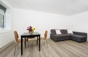 uma sala de estar com uma mesa e um sofá em Modern Apartment in South West London em Londres