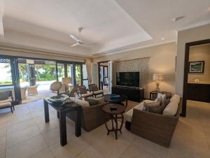 a living room with couches and a tv at Villa Magnifique by Simply-Seychelles in Eden Island