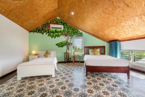 1 dormitorio con 2 camas, mesa y árbol en La Casa Tra Que en Hoi An