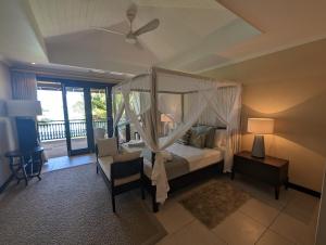 a bedroom with a canopy bed and a balcony at Villa Magnifique by Simply-Seychelles in Eden Island +31 photos