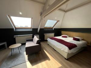 a bedroom with a bed and a couch and two windows at Hotel Montovani in Bruges