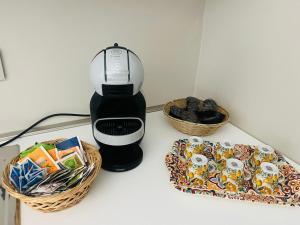 eine Kaffeemaschine neben einem Korb mit Keksen in der Unterkunft Il primo sasso in Matera