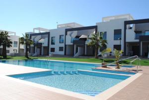 een zwembad voor een gebouw bij 2 bedroom apartment at Paradise Oasis Beach-ORIHUELA COSTA- LA ZENIA BEACH-ALICANTE in Orihuela-Costa