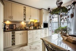 a kitchen with white cabinets and a table at Die Kleine Oase 3 im Wohnhaus in Stuhr