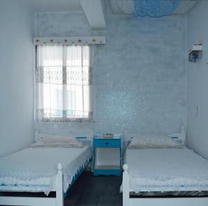 two twin beds in a room with a window at Studios Soula in Alonnisos