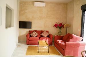 a living room with two red couches and a tv at Cathedral Sevilla Views in Seville