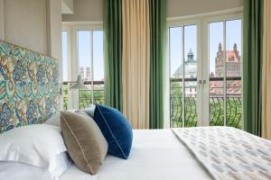 a bedroom with a bed with a view of the city at Rocco Forte The Charles Hotel in Munich