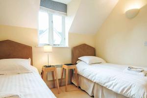 a bedroom with two beds and a window at Mill Village 75, Tide Cottage - P in Somerford Keynes +13 photos