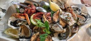 a plate of oysters and seafood on a table at Affitto frassanito in Otranto