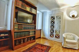 a living room with a tv and a book shelf at Domus Orvieto in Orvieto