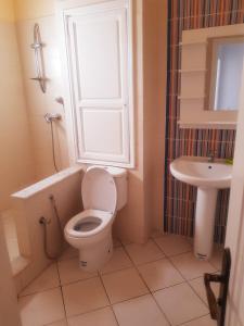 a bathroom with a toilet and a sink at Appartement très coquet dans résidence in Hammamet