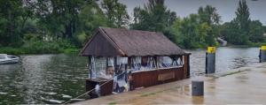ein kleines Haus inmitten eines Flusses in der Unterkunft Das Floß - Biberspur in Brandenburg an der Havel