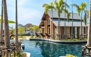 una piscina en un complejo con palmeras en Private sea view apartment at Mida Grande Resort, en Surin Beach